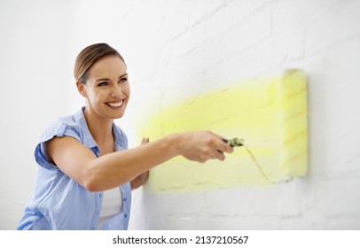 Painting Made Easy. Shot Of An Attractive Female Painting Her Wall With A Paint Roller.