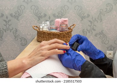 Painting The Nails Of A Woman's Hands With Red Lacquer