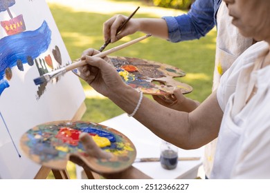 Painting on canvas, two people holding palettes and brushes outdoors. Art, creativity, collaboration, nature, artists, teamwork - Powered by Shutterstock