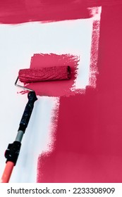 Painting and refreshing the wall with viva magenta color paint using roller, color of the year 2023 - Shutterstock ID 2233308909