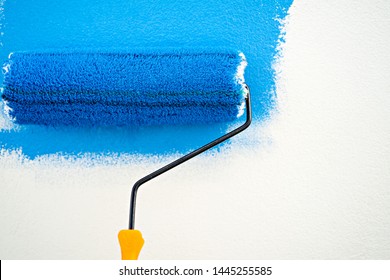 Painting Roller With Blue Stroke At Wall Background.