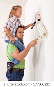 Painting The Room With Dad - Little Girl Using Paint Roller Playing Piggyback With Her Father