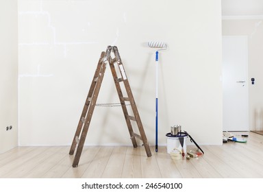 Painting Supplies With Ladder Against A Wall To Be Repainted