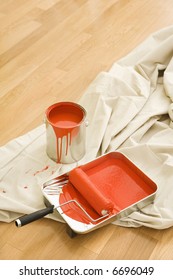 Painting Supplies On Drop Cloth On Wood Floor.