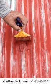 Painting the surface of a sheet of Galvanized Iron or GI corrugated metal with rust inhibiting red oxide primer. - Shutterstock ID 2180365867