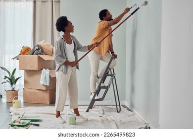 Painting, teamwork or black couple home renovation, diy or house remodel together with paintbrush or roller. Happy smile, woman and African man love working on wall with partnership or collaboration - Powered by Shutterstock