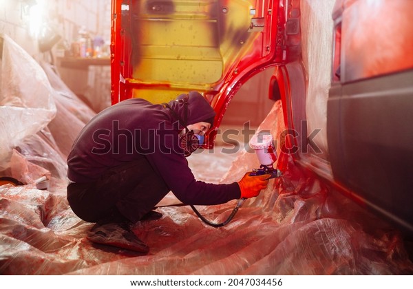 Painting a\
truck in a spray booth, a man molar\
car