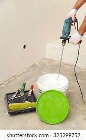 Painting Walls And Ceilings. Painter Paint Stir Using A Mixer