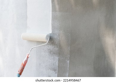 Painting of walls in a white color. Close-up house paint roller, home improvements, horizontal view with copy space. - Shutterstock ID 2214958467