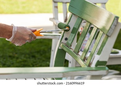 Painting Wooden Chair With Paint Roller. Renovation Renewing Recycling Wooden Furniture. Person Hand With Paint Roller Painting Chair Outside.