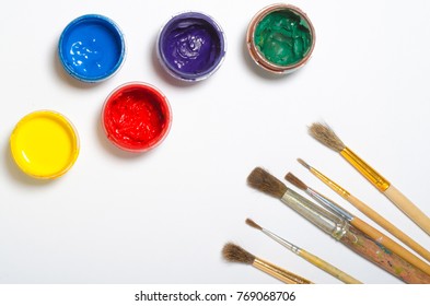 Paints In Jars And A Brush On A White Sheet Of Paper, Top View