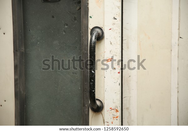 Paint-stained door\
handle. Door handle of the door to  painting chamber of car\
service. Paint-smudged door\
close-up.