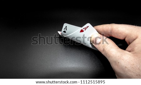 A pair of aces against a black background