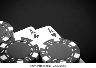 A pair of aces and chips on a casino table
