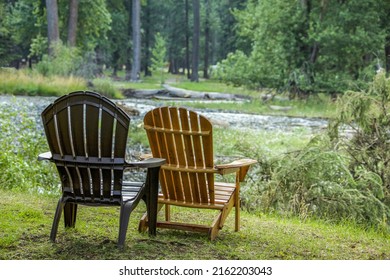 Pair Of Adirondack  Lounge Chairs Sitting On Bank Of Joseph Lake In Eastern Oregon