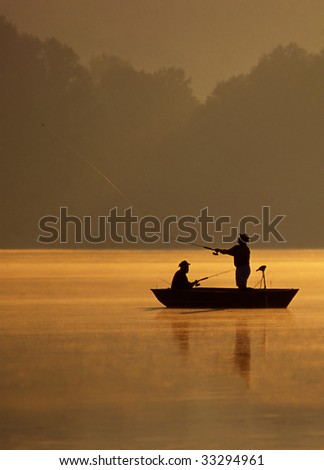 A pair of anglers are fishing on a beautiful golden morning.