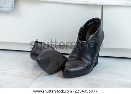 pair of black boots with high heels in front of a white closet. High quality photo