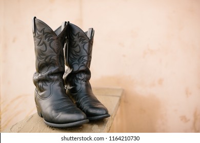 A Pair Of Black Cowboy Boots On Display