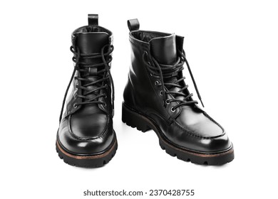 Pair of black leather boots, dress boots for men. Black brogue boots on a white background. Man's legs in black jeans and brown leather boots.