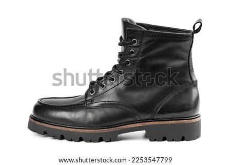Pair of black leather boots, dress boots for men. Black brogue boots on a white background. Men fashion in leather boots. Man's legs in black jeans and brown leather boot.