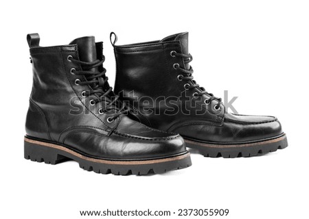 Pair of black leather boots, dress boots for men, men ankle high boots. Man's legs in black jeans and brown leather boots.