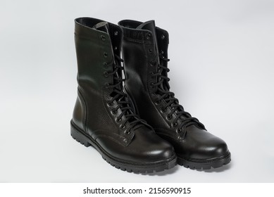 A Pair Of Black Leather Military Boots Isolated On A White Background.