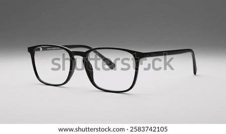 A pair of black rectangular eyeglasses with a sleek modern frame rests on a white surface, symbolizing style, vision, and intellectual elegance.