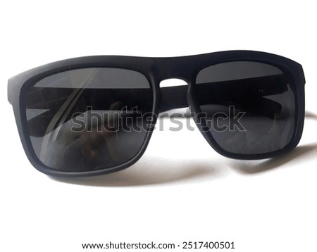 A pair of black sunglasses with large, rectangular frames and dark lenses isolated white background 