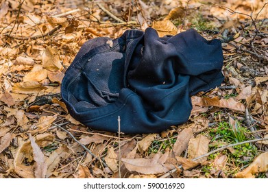 Pair Of Black Sweat Pants Laying On Ground Covered With Dead Leaves In A Woodland Park