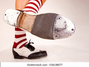 Pair of black and white tap shoes with red and white striped socks