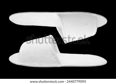 Pair of blank soft white home slippers, design mockup. House plain flops mock up template side view. White comfortable slippers isolated on black background with cut out. Clear warm domestic sandals.