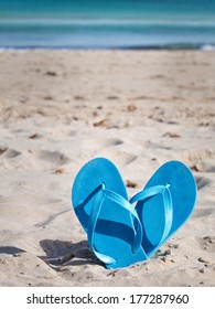 Pair Of Blue Flip Flops On Sand Beach