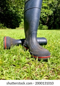 Pair Of Blue Rubber Work Boots Tossed Aside On Green Grass After Doing Chores