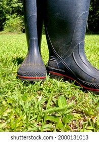 Pair Of Blue Rubber Work Boots Tossed Aside On Green Grass After Doing Chores