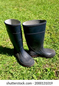 Pair Of Blue Rubber Work Boots Tossed Aside On Green Grass After Doing Chores