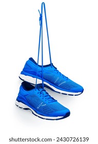 A pair of blue running shoes hanging from a hook. Isolated on a white background.