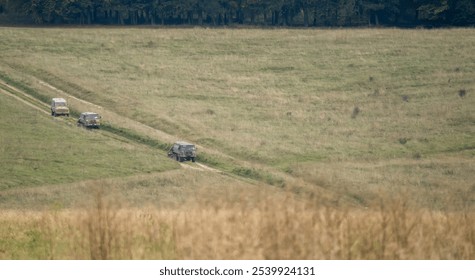a pair of British army bae systems, Puch, Daimler, Pinzgauer High-Mobility All-Terrain 6x6 vehicles towing a 105mm Light Artillery Guns on a military exercise