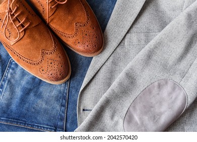 A Pair Of Brown Suede Derby Shoes And Jeans On Light Tweed Blazer. Top View.