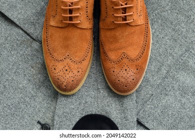 A Pair Of Brown Suede Derby Shoes With Grey Tweed Blazer. Top View.