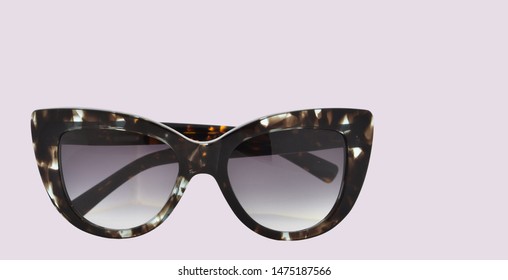 Pair of cateye sunglasses in pinkish background