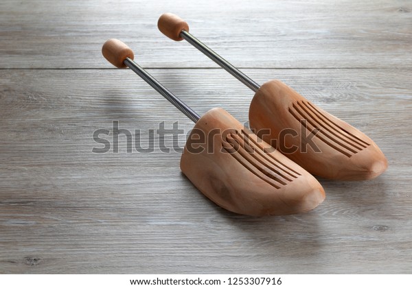 pair of cedar wood shoe trees , shoe stretchers\
on a wooden floor, room for\
text