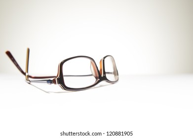 A pair of classic framed reading glasses resting on a white background with space for text - Shutterstock ID 120881905