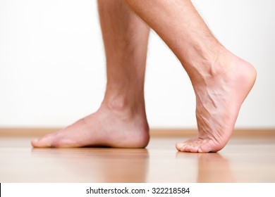 Pair of clean male feet without any illness making a step.