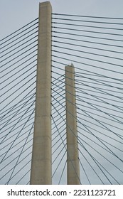 Pair of concrete pylons and cables of cable-stayed bridge viewed from below. A Harp design bridge with stays running nearly parallel between tower and deck attachments. - Shutterstock ID 2231123721