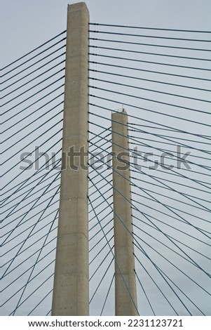 Pair of concrete pylons and cables of cable-stayed bridge viewed from below. A Harp design bridge with stays running nearly parallel between tower and deck attachments.
