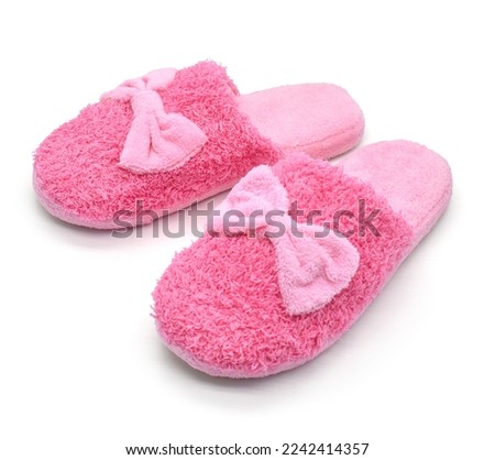 Pair of cozy pink house slippers with bows isolated on white background with clipping path