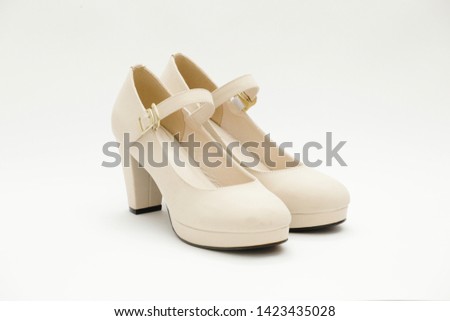 A pair of creamy-beige ankle-strap high heels with front platform isolated on white background.