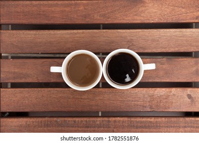 Ein Paar Cups türkischen Kaffee mit und ohne Milch auf Holztisch. Draufsicht