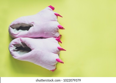 Pair Of Cute Pink Monster Foot Slippers With Big Claws On Yellow Background. Pop Art Style. Copy Space. Top View.