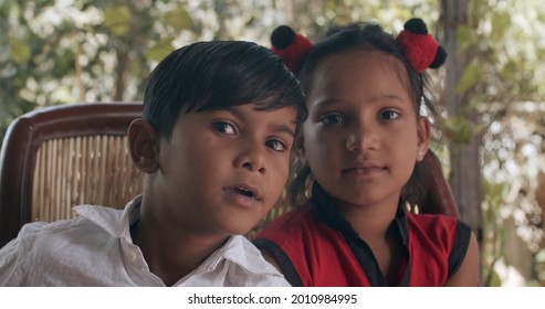 A Pair Of Cute South Asian Children On A Chair